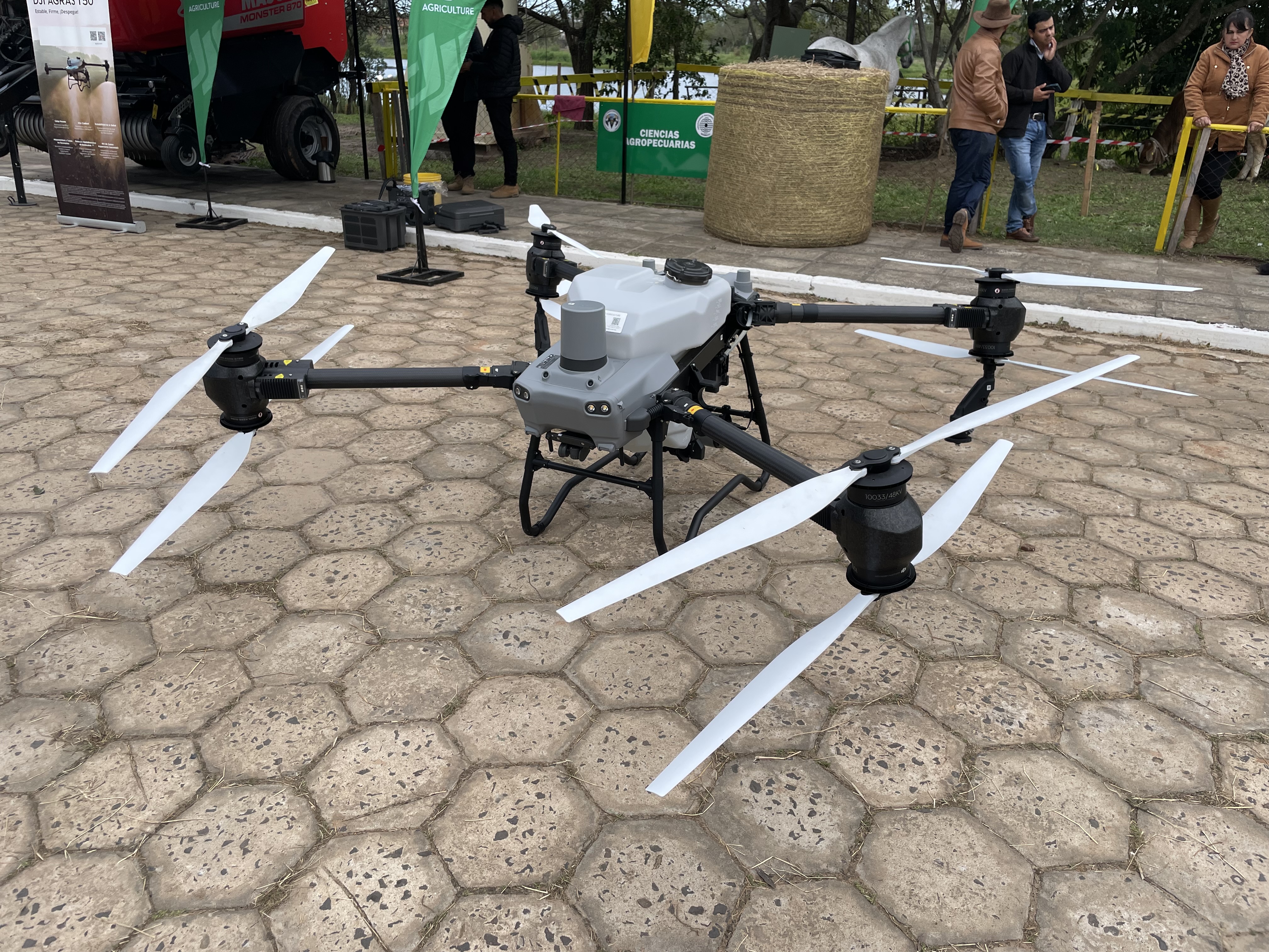 DJI Agras T50 commercial agriculture drone stationary on a paved surface at an agricultural exhibition