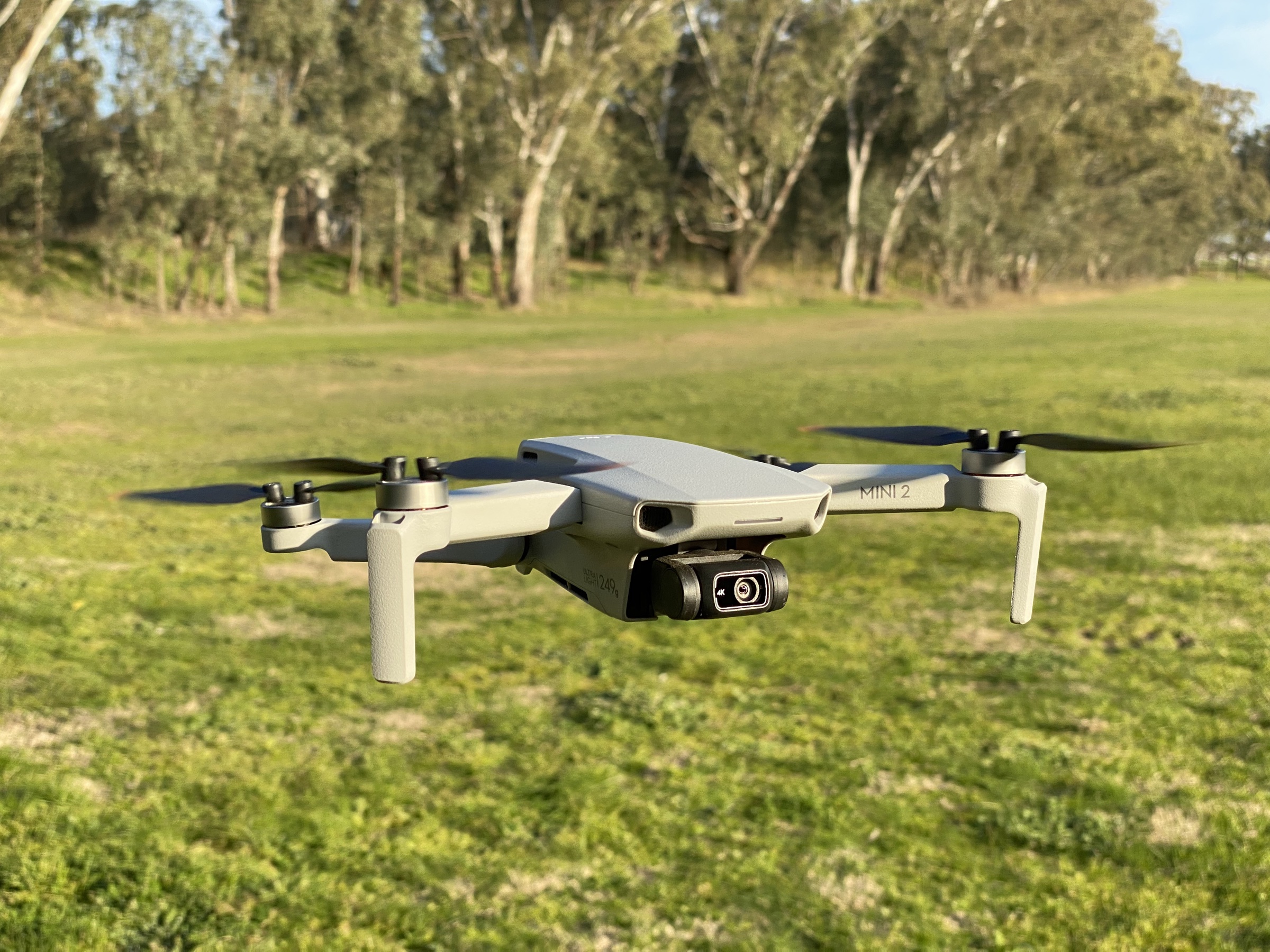 DJI Mini 2 sub-250g consumer drone in active flight against an open sky
